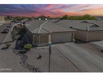 Charming single-story home with a well-manicured desert landscape, tile roof, and two-car garage at sunset at 1769 E Jacob St, San Tan Valley, AZ 85140
