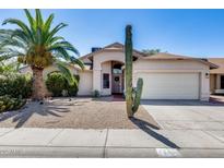 Inviting single-story home with desert landscaping, mature palm tree, and private two-car garage at 4443 W Escuda Dr, Glendale, AZ 85308