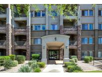 Charming building entrance featuring stone accents, well-maintained landscaping, and covered access at 5450 E Deer Valley Dr # 1004, Phoenix, AZ 85054