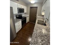 Updated kitchen features stainless steel appliances, granite countertops and white cabinets at 17841 N Del Webb Blvd, Sun City, AZ 85373