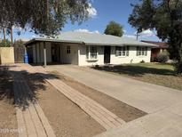 Charming single-story home featuring a brick driveway and front yard with mature landscaping and a covered front porch at 3001 N 21St Ave, Phoenix, AZ 85015