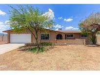 Charming single-story brick home with a well-maintained front yard and a convenient two-car garage at 4556 W Cholla St, Glendale, AZ 85304