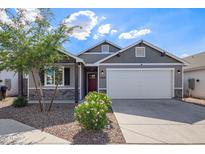 Charming single-story home featuring a red front door, a two-car garage, and desert landscaping at 5808 S 12Th Ln, Phoenix, AZ 85041