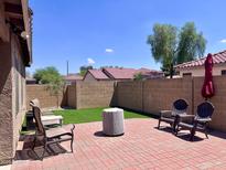 Cozy backyard featuring a brick patio, outdoor seating, and lush landscaping, perfect for entertaining at 6049 S Wilson Dr, Chandler, AZ 85249