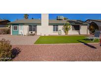 Spacious backyard featuring a lush lawn, mature palm trees, and a well-maintained patio area at 643 W Medina Ave, Mesa, AZ 85210