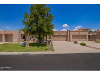 Charming single-story home with a well-manicured lawn, desert landscaping, and a two-car garage at 10318 E Michigan Ave, Sun Lakes, AZ 85248
