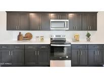Modern kitchen features stainless steel appliances, sleek black cabinetry, and bright white countertops at 1219 N 13Th St, Coolidge, AZ 85128