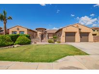 Charming single-story home featuring a well-manicured lawn and an attached two-car garage at 14372 W Cypress St, Goodyear, AZ 85395