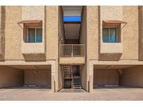 View of building exterior with garages and staircases leading to the units above at 151 E Broadway Rd # 103, Tempe, AZ 85282