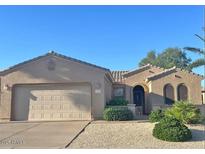 Charming single-story home featuring a tile roof, arched windows, desert landscaping, and a two-car garage at 16412 W Peppertree Ct, Surprise, AZ 85387