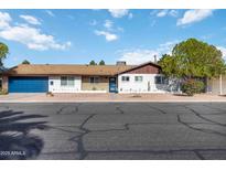 Charming single-story home with a blue garage door, desert landscaping, and inviting curb appeal at 224 N 58Th St, Mesa, AZ 85205