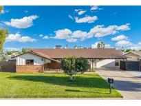 Charming single-story home features a well-manicured lawn, a large driveway, and a cozy front porch at 2261 E Decatur St, Mesa, AZ 85213
