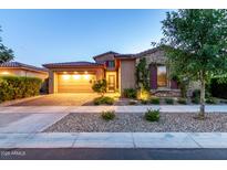 Charming single-Gathering home featuring a stone facade, a two-car garage, and well-maintained landscaping at twilight at 5328 S Wesley Cir, Mesa, AZ 85212
