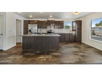 A spacious kitchen showcases a center island, stainless steel appliances, and stylish wood-look flooring at 5601 W Missouri Ave # 150, Glendale, AZ 85301