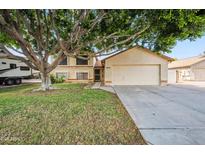 Charming home with a large tree shading the front yard and a two-car garage at 608 E Arabian Ct, Gilbert, AZ 85296