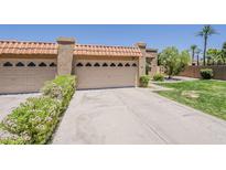 Beige home featuring 2-car garage with tile roof and well-maintained landscaping at 9196 E Evans Dr, Scottsdale, AZ 85260
