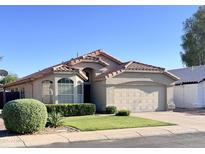 Charming home featuring a tile roof, a two-car garage, manicured landscaping, and a well-maintained front yard at 1463 E Silver Creek Rd, Gilbert, AZ 85296