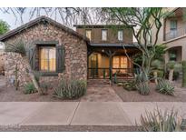 Charming stone-clad home with a cozy front porch and well-manicured desert landscaping at 17728 N 92Nd Pl, Scottsdale, AZ 85255