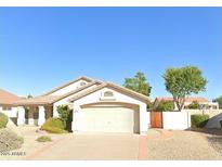 Charming single-story home featuring a large garage, desert landscaping, and a well-maintained lawn at 19697 N 66Th Ave, Glendale, AZ 85308
