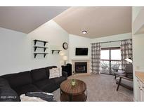 Inviting living room featuring a fireplace, balcony access, and soaring vaulted ceilings at 205 N 74Th St # 248, Mesa, AZ 85207