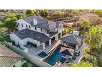 Stunning aerial view of a two-story home with a pool, spa, and covered outdoor living area at 20866 W Werner Pl, Buckeye, AZ 85396