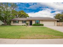 Charming single story home featuring a well-manicured lawn and a two car garage at 3010 E Cortez St, Phoenix, AZ 85028