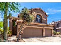 Two-story home with a three-car garage, desert landscaping and a stucco exterior with an arched window at 3055 N Red Mountain -- # 98, Mesa, AZ 85207
