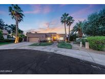 Charming single-story home boasts desert landscaping, palm trees, and a welcoming facade at sunset at 306 E Sarah Ln, Tempe, AZ 85284