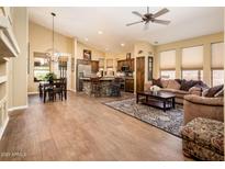 Open-concept living room with a stacked stone kitchen island, wood floors, and plenty of natural light at 30844 N 41St Pl, Cave Creek, AZ 85331