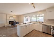 Bright kitchen with white cabinets, an island and stainless steel appliances offering modern and functional design at 3118 S Los Altos Dr, Mesa, AZ 85202