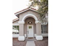 Charming front entrance features a white door with glass panes, framed by an arched entryway with tan pillars and an overhead light fixture at 3446 N Ravine --, Mesa, AZ 85215