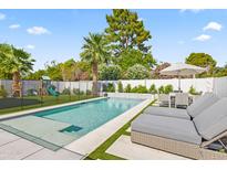 Inviting backyard pool with lounge chairs, dining set, lush landscaping, and a play area at 6721 N 14Th Pl, Phoenix, AZ 85014