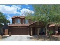 Two-story home featuring a tile roof, front porch, landscaped front yard, and an attached two-car garage at 7224 W Pioneer St, Phoenix, AZ 85043
