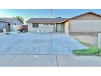 Home featuring a large driveway, small lawn, and front entrance at 7940 W Avalon Dr, Phoenix, AZ 85033