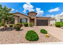 Well-kept single-story home with desert landscaping, stone accents, and a two-car garage door at 9452 W Parkside Ln, Peoria, AZ 85383