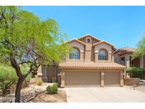 Charming two-story home featuring a desert landscape and a three-car garage at 10490 E Morning Star Dr, Scottsdale, AZ 85255