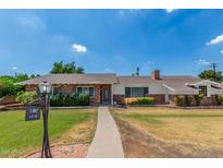 Charming single-story brick home with a well-manicured lawn and a welcoming pathway leading to the front door at 1407 E 1St St, Mesa, AZ 85203