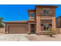 Two-story home with a two car garage, a desert rock yard and a quaint, covered entry way at 16284 W Desert Mirage Dr, Surprise, AZ 85379