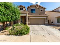 Charming two-story home with a well-manicured lawn and a two car garage in a residential neighborhood at 17413 W Mandalay Ln, Surprise, AZ 85388