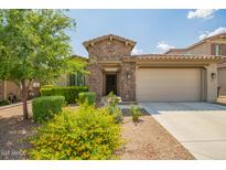 Charming home featuring a stone facade, tile roof, and meticulously landscaped front yard at 22660 N 122Nd Ave, Sun City, AZ 85373