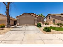 Inviting single-story home with a well-maintained lawn and a spacious two-car garage at 42458 W Desert Fairways Dr, Maricopa, AZ 85138