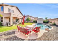 Beautiful backyard featuring a pool, patio with outdoor seating, and a well-maintained lawn at 4408 W Summerside Rd, Laveen, AZ 85339