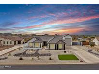 Stunning single-story home with desert landscaping, side-entry garage, and mountain views against a vibrant sunset sky at 460 W Chase St, San Tan Valley, AZ 85143
