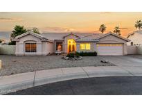 Charming single-story home showcasing manicured desert landscaping and a warm, inviting entrance at sunset at 462 N Bedford Ct, Chandler, AZ 85225