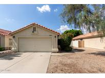 Charming single-story home featuring a red tile roof, two-car garage, and low-maintenance front yard at 7826 W Mcrae Way, Glendale, AZ 85308