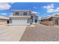 Charming two-story home featuring a well-maintained front yard with a spacious driveway and attached two-car garage at 8750 W Granada Rd, Phoenix, AZ 85037