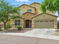 Charming two-story stucco home with a well-manicured front yard and attached two car garage at 10010 W Illini St, Tolleson, AZ 85353