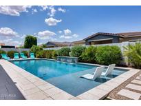 Beautiful pool features in-pool lounge chairs, lush landscaping, and serene water features at 1202 E Nolan Pl, Chandler, AZ 85249