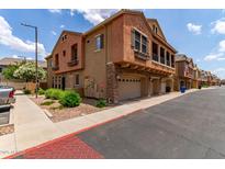 Charming townhome showcasing unique architecture with a stone-accented facade and private garages at 1350 S Greenfield Rd # 1123, Mesa, AZ 85206