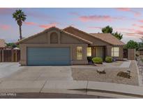 Inviting single-story home featuring desert landscaping, a two-car garage, and a mature palm tree against a picturesque sky at 1672 W Butler Dr, Chandler, AZ 85224